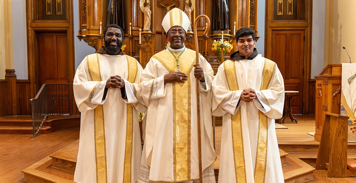 Friars Baudry Metangmo, OFM Cap. (L) and Alwin Anthonysamy, OFM Cap. (R) pose with Bishop Feudjio at their Diaconate Ordination at St. Bonaventure Chapel.