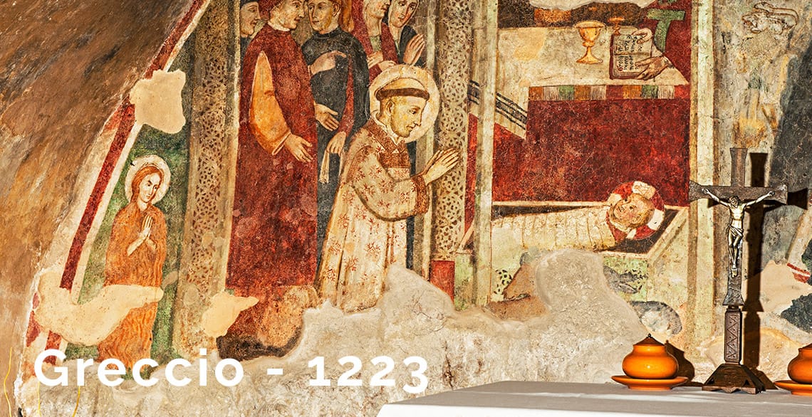 A fresco painting in the santcuary at Greccio, Italy depicts St. Francis of Assisi adoring the Christ child in a creche.